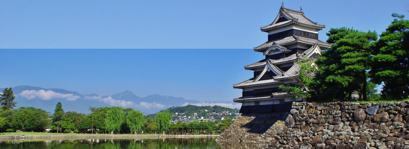 松本観光スポット 松本城の天守と水面に映る白黒のコントラスト、背景に広がる北アルプスの山々